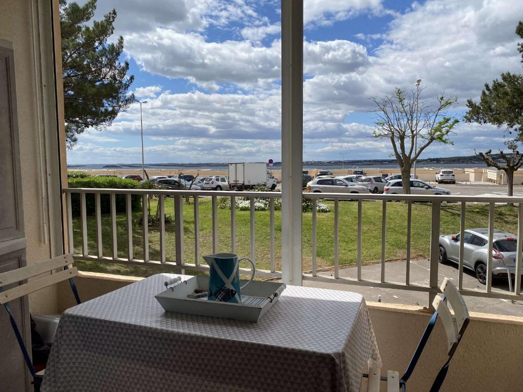 - une table sur un balcon avec vue sur le parking dans l'établissement Bel Appartement T1 avec Loggia à Balaruc-les-Bains - FR-1-553-254, à Balaruc-les-Bains