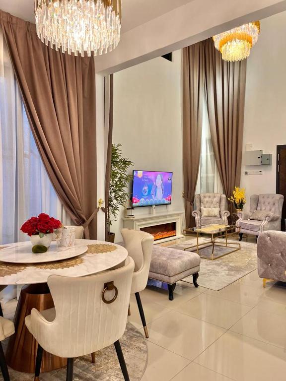 a living room with a table and chairs and a tv at Resthouse Asyura in Malacca