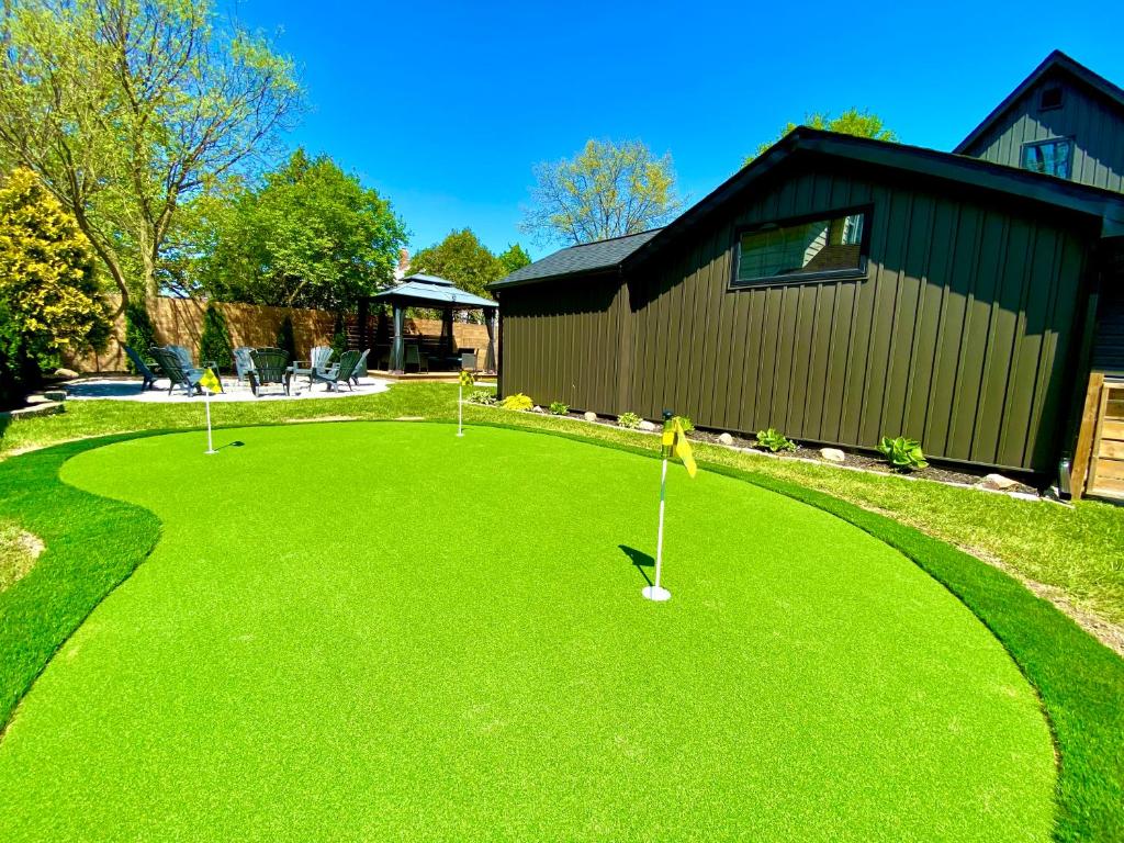 un patio con tres pelotas de golf en la hierba en Stylish Downtown Kingsville Getaway with Putting Green, Firepit & Games en Kingsville