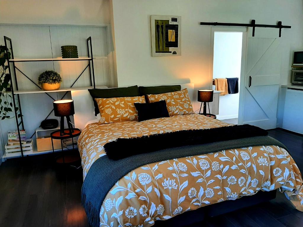 a bedroom with a large bed and two lamps at Tree View Studio in Tauranga