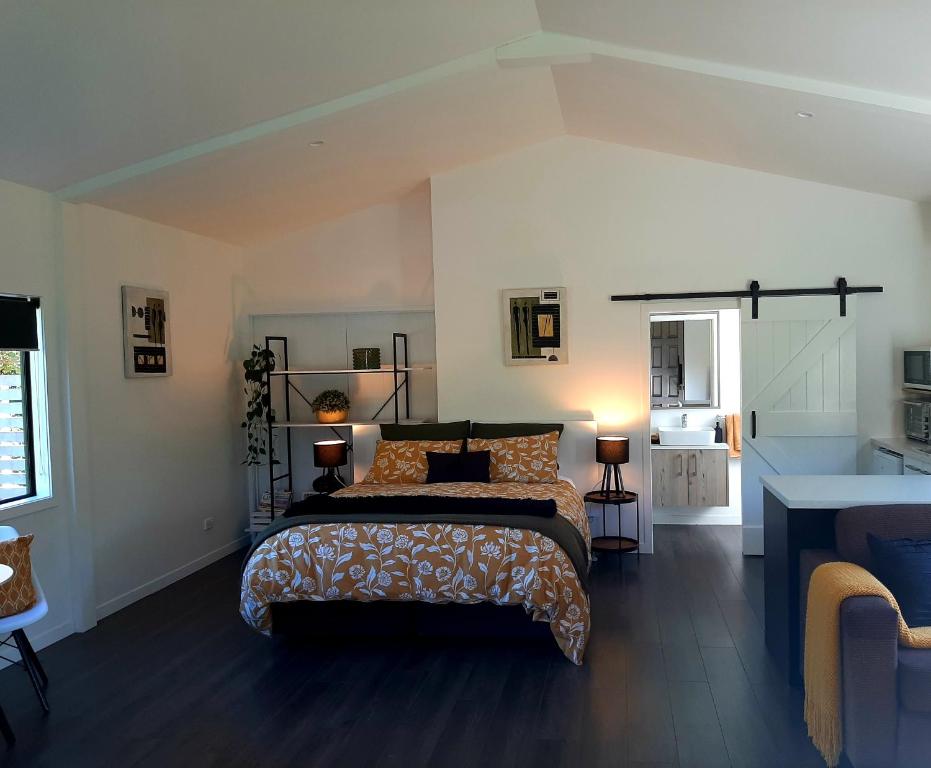 een slaapkamer met een groot bed in een kamer bij Tree View Studio in Tauranga
