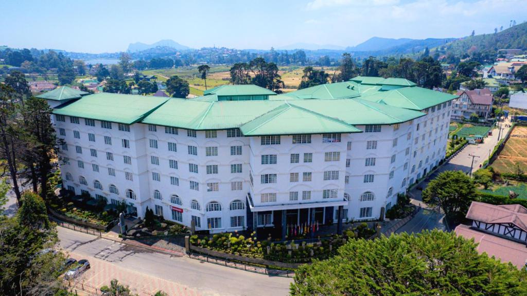an aerial view of a large white building with a green roof at Araliya Green City Hotel in Nuwara Eliya