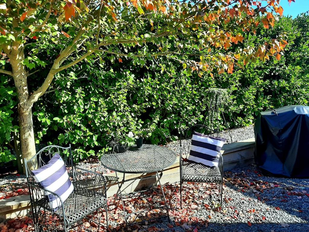 a table and chairs and a table and a tree at Tree View Studio in Tauranga