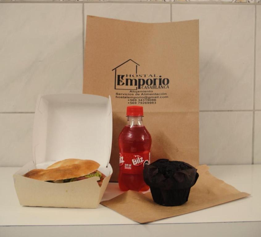 卡薩布蘭卡的住宿－Hostal Emporio，三明治和一瓶苏打水和一杯蛋糕