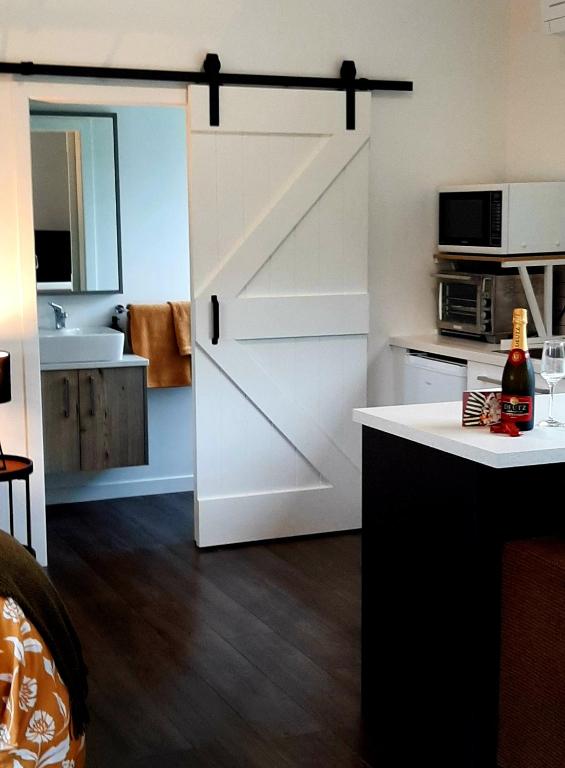 a kitchen with a sliding barn door in a room at Tree View Studio in Tauranga