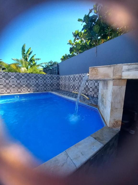 uma piscina com uma fonte de água em Pousada Coqueirais em Mongaguá