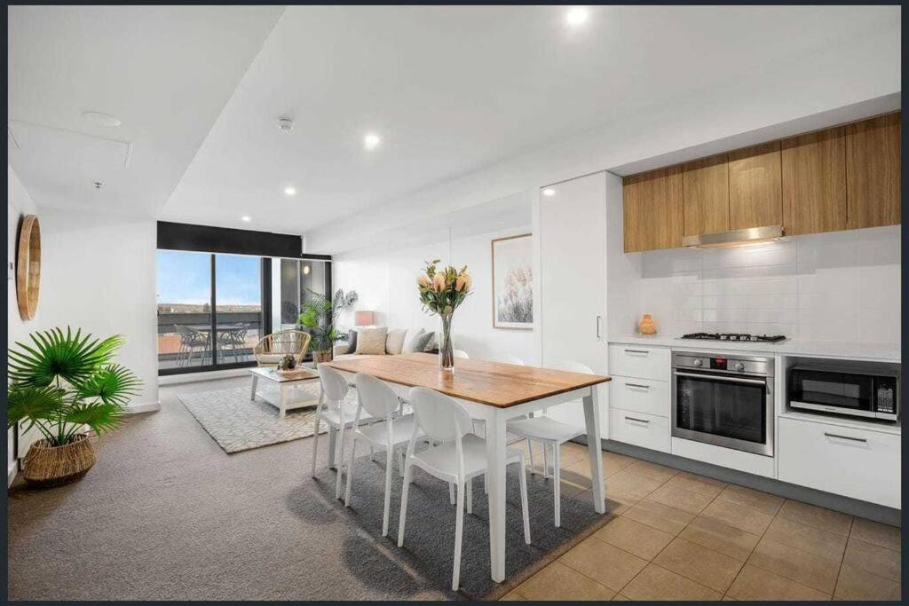 eine Küche mit einem Tisch und Stühlen im Zimmer in der Unterkunft Luxe Cityscape Living in Adelaide