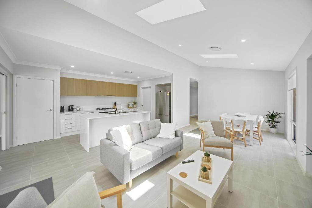 una sala de estar con un sofá y una mesa en Fairway to Heaven, en Sussex Inlet