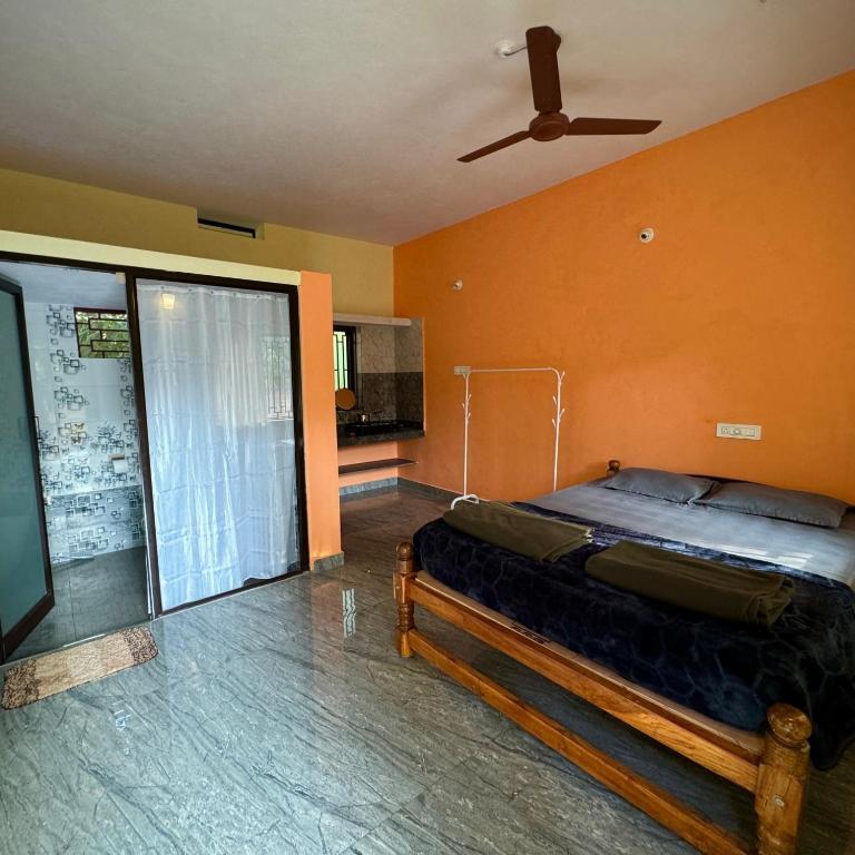 1 dormitorio con 1 cama y ventilador de techo en Wild Village Stay Gokarna en Gokarna