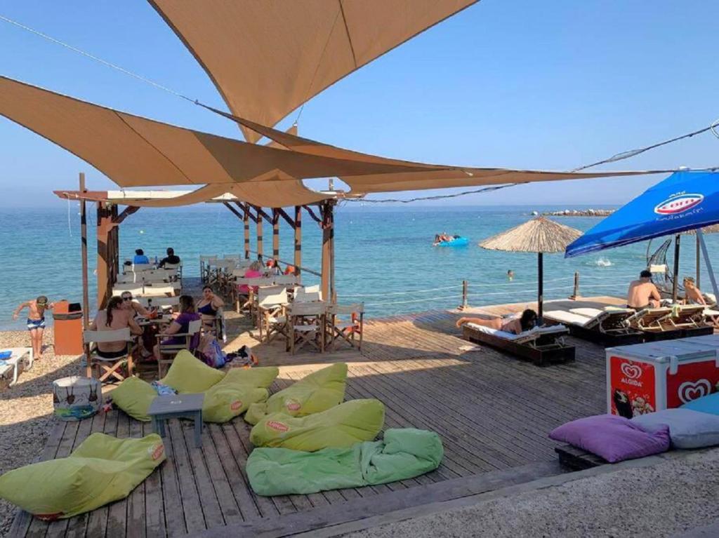 a beach with chairs and umbrellas and the ocean at Blue Flag Award Winning Ormos Lo Beach: Home 1 in Vrontados