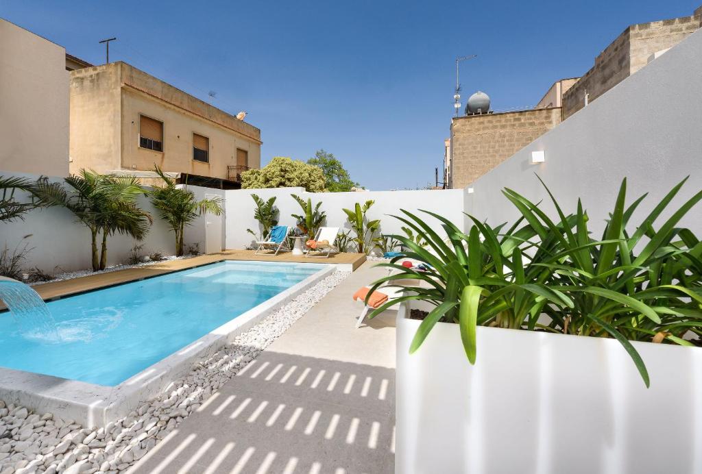 a swimming pool on the side of a house at Andromeda Hotel in San Vito lo Capo