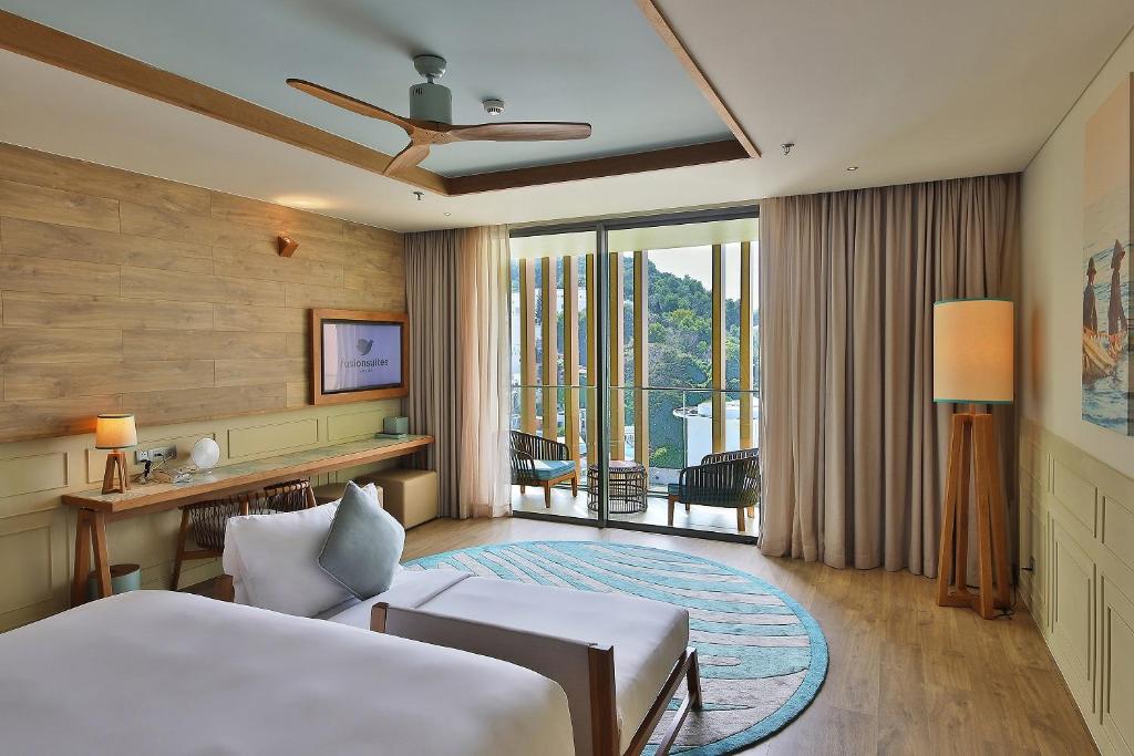 a hotel room with a bed and a balcony at Fusion Suites Vung Tau in Vung Tau