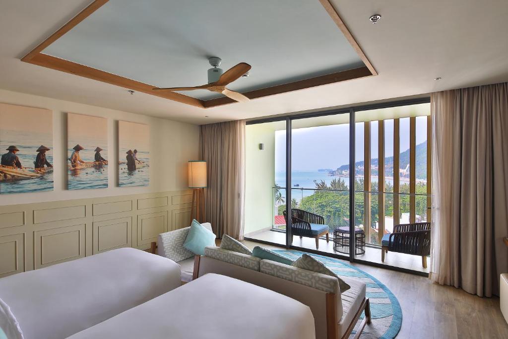 a hotel room with a bed and a large window at Fusion Suites Vung Tau in Vung Tau