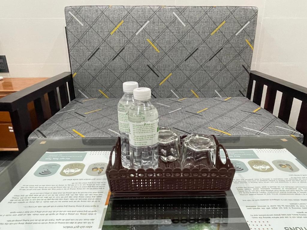a basket of water bottles and glasses on a table at Hưng Thịnh Motel in Dong Hoi