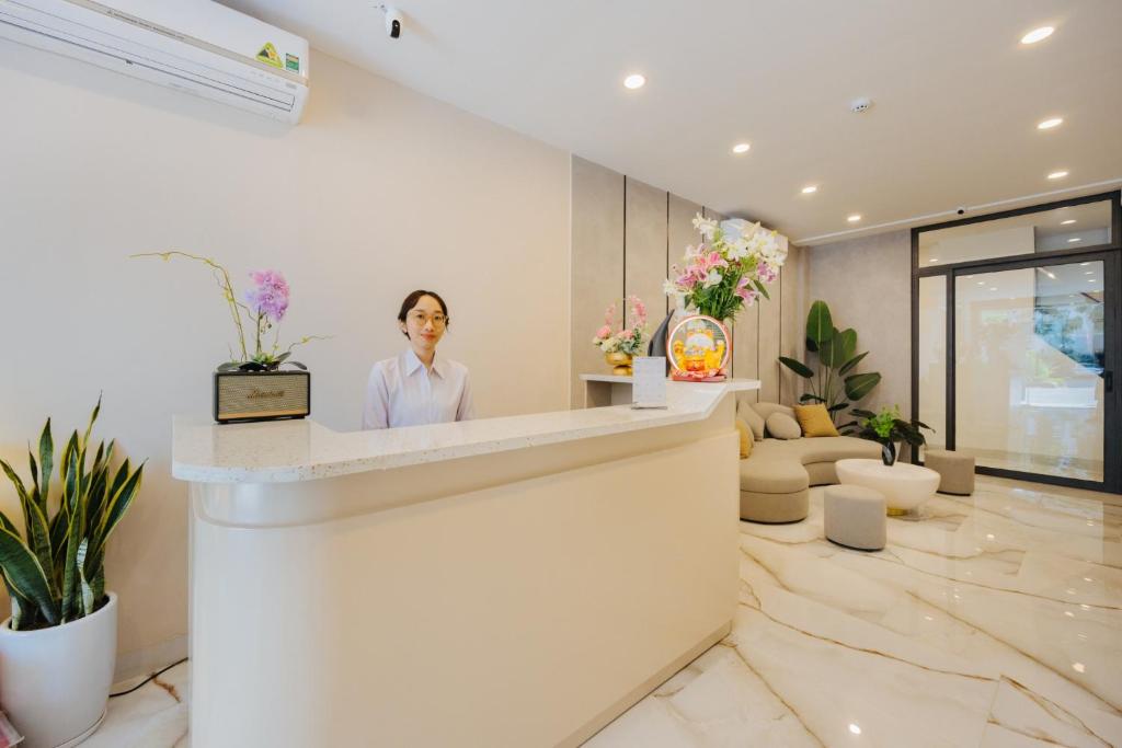 a man standing at a counter in a lobby at Muse Hanoi Serenity Suites in Hanoi
