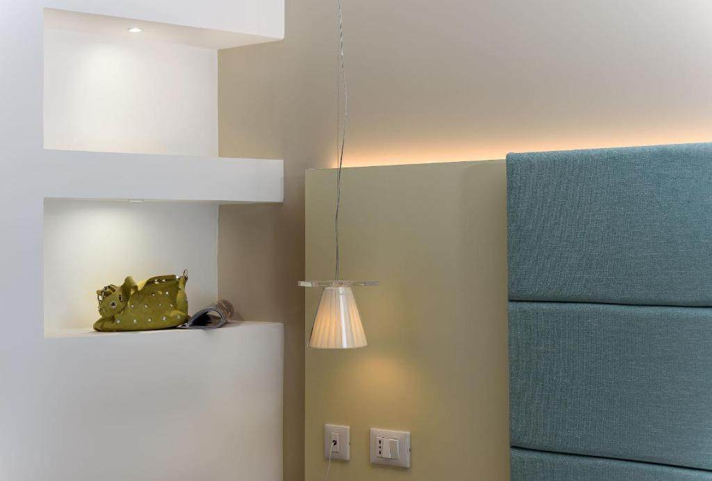 a kitchen with a refrigerator and a light on a wall at Andromeda Hotel in San Vito lo Capo