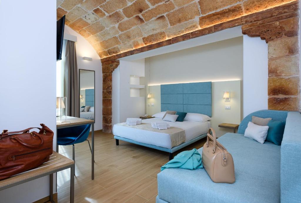 a hotel room with a bed and a couch at Andromeda Hotel in San Vito lo Capo
