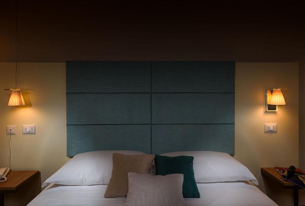 a bedroom with a bed with a blue headboard at Andromeda Hotel in San Vito lo Capo
