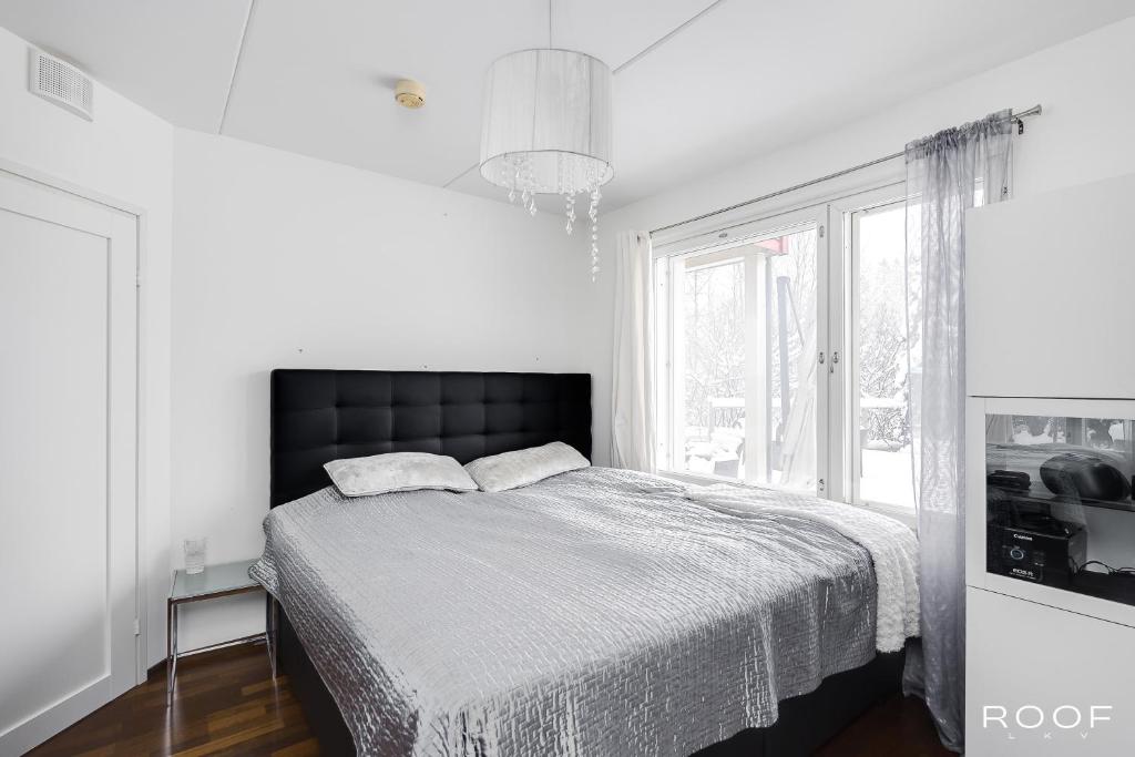 Habitación blanca con cama y ventana en Cozy Holiday Home with Outside Jacuzzi, en Espoo