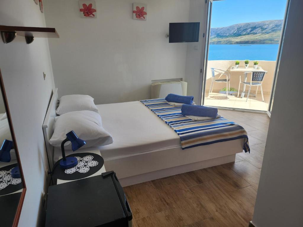 a bedroom with a bed with a view of the ocean at AtlantisPagNovalja in Zubovići