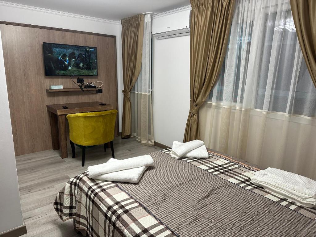 1 dormitorio con cama, escritorio y ventana en Pensiunea Cascada Putnei, en Lepşa