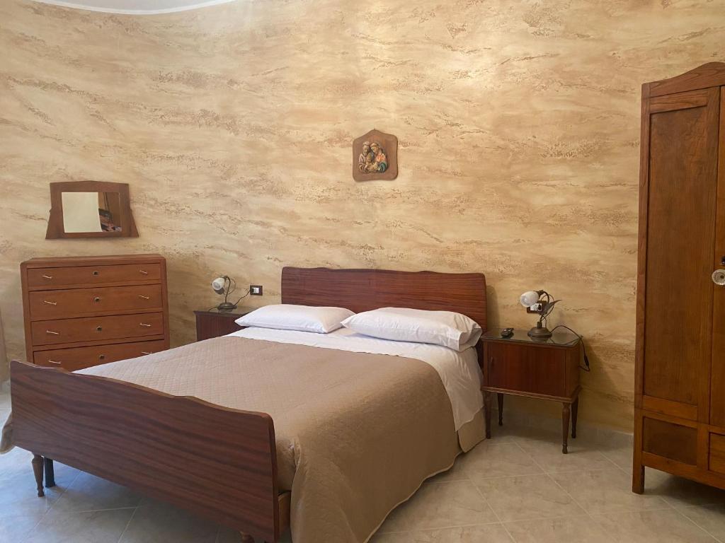 a bedroom with a large bed with two night stands and a dresser at appartamento NONNA ROSA in Morano Calabro