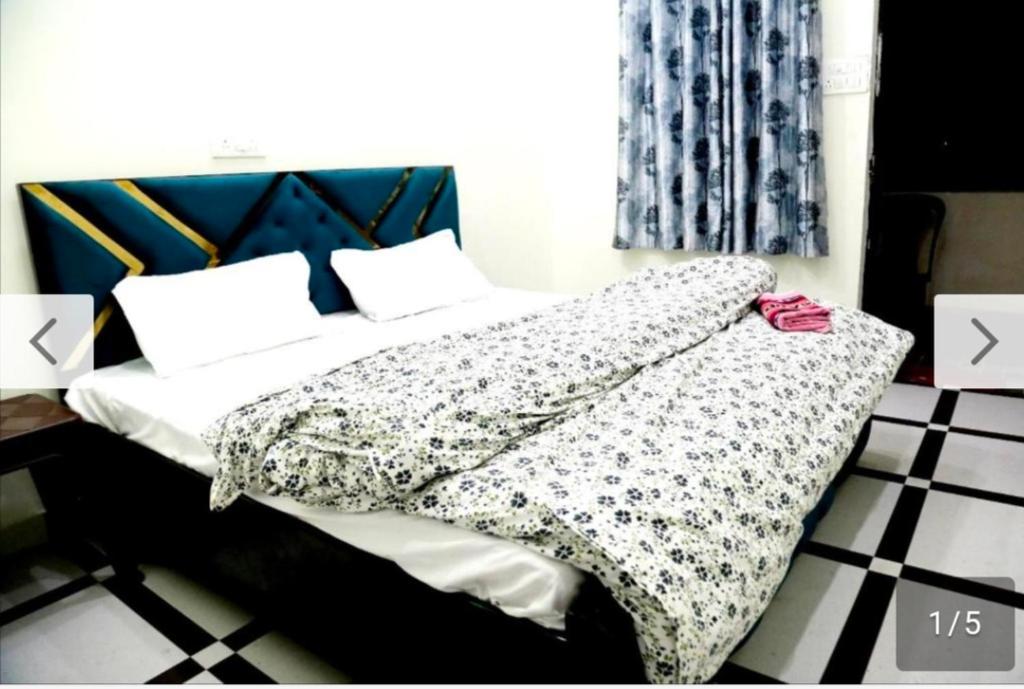 1 cama con edredón y almohadas en blanco y negro en Jolly Hill Stay, en Doiwāla