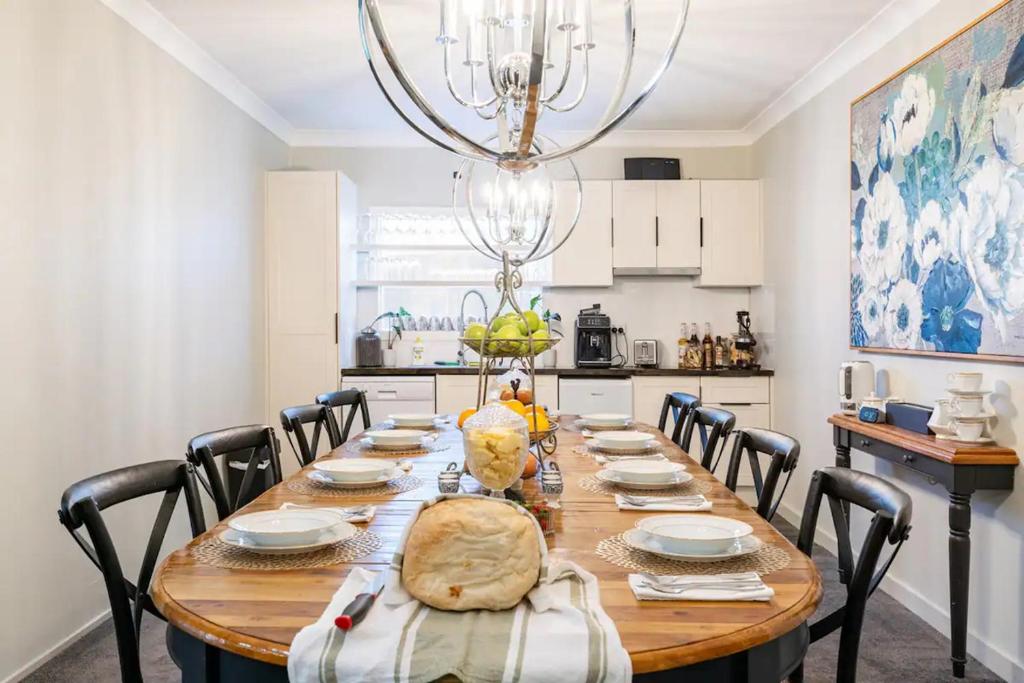 a dining room with a table with chairs and a chandelier at Cypress BnB in Hervey Bay