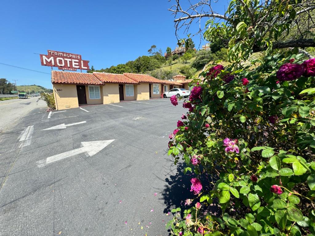 een lege parkeerplaats met een motelbord en bloemen bij Tamalpais Motel in Mill Valley
