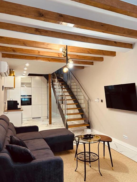 un salon avec un canapé et un escalier dans l'établissement Appartement au centre du Port de Bonifacio, à Bonifacio