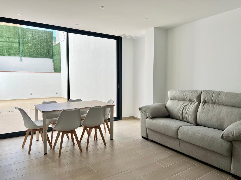un soggiorno con un tavolo e un divano di Moderno apartamento con gran terraza a Roses