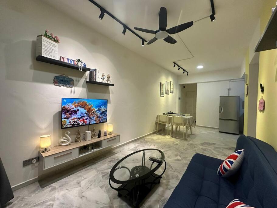 een woonkamer met een blauwe bank en een flatscreen-tv bij 1-6 Pax BBQ + Hot Pot - Relaxing Seaview in Port Dickson