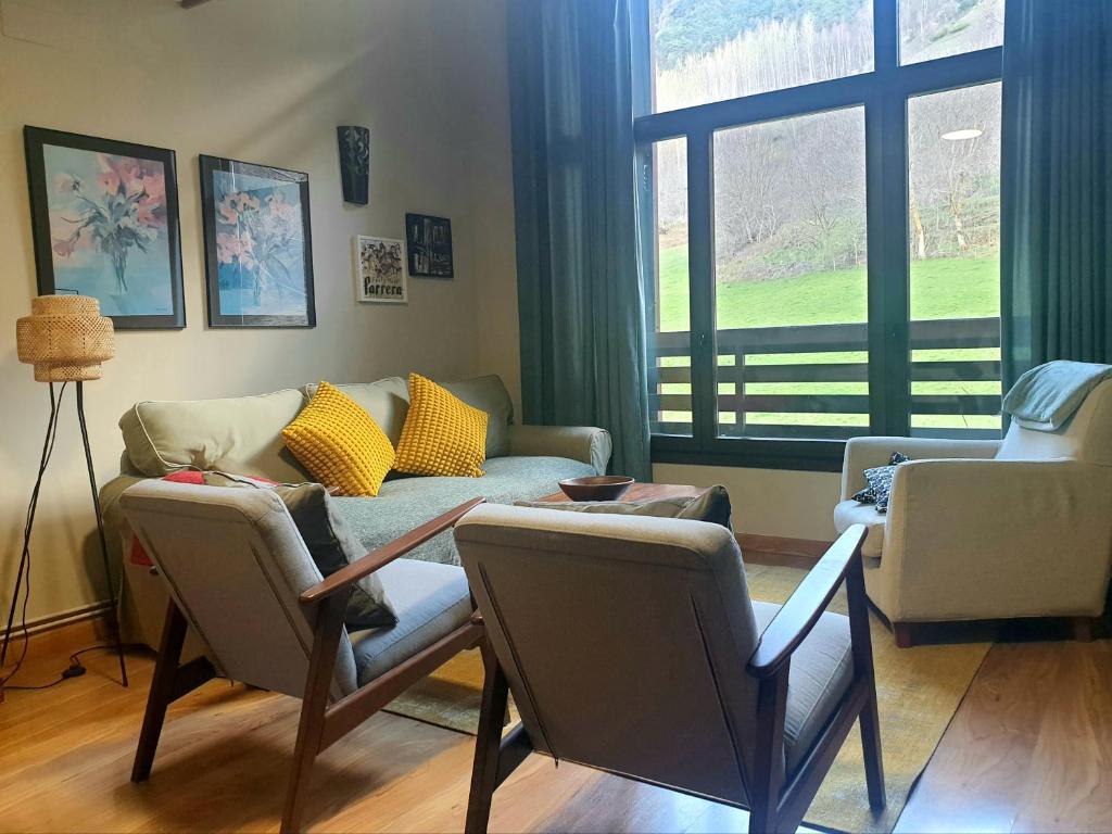 Areu的住宿－Dúplex Àreu, Pallars，带沙发和椅子的客厅以及窗户。