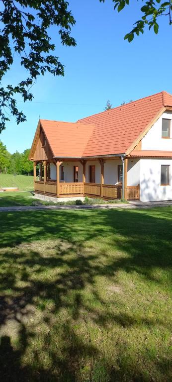 una casa grande con un gran patio delante en Kőszikla Kulcsosház, en Izvoare