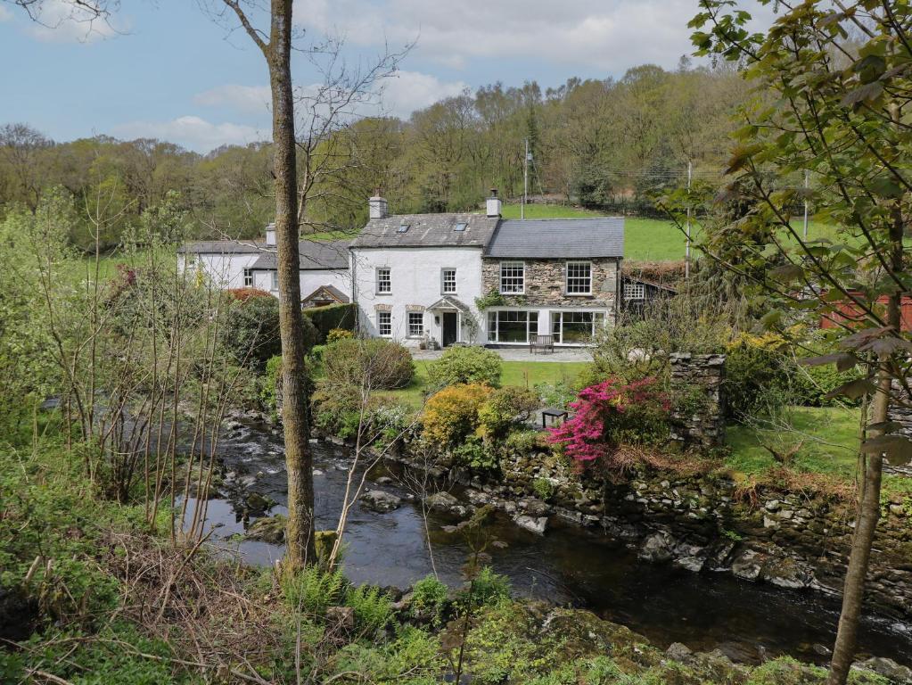 a house with a river in front of it at Beck Cottage in Ulverston