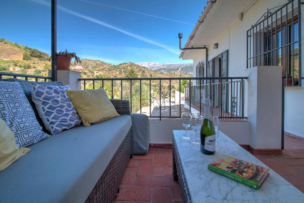 a couch and a table on a balcony with a view at Finca el Almendro Archez in Árchez