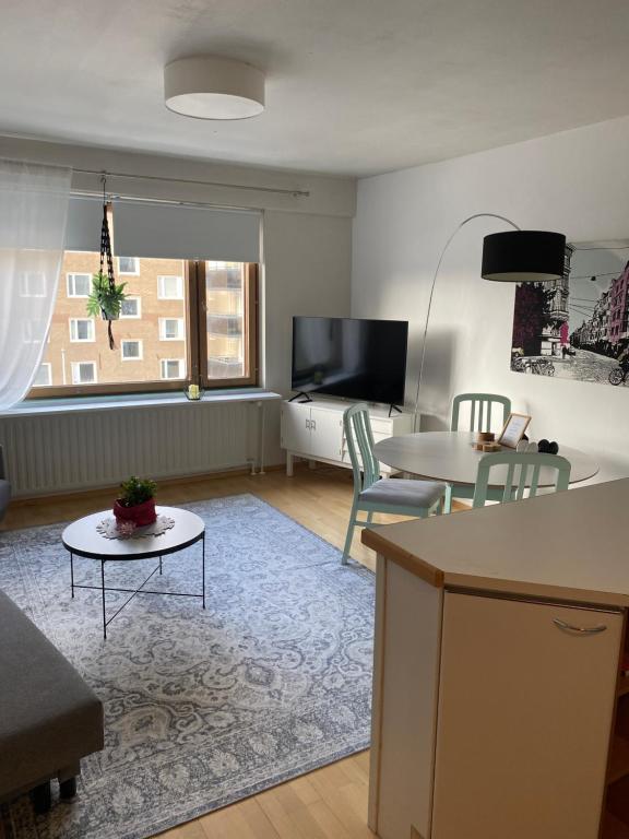 uma sala de estar com um sofá e uma mesa em City apartment Pikkuvuori em Turku