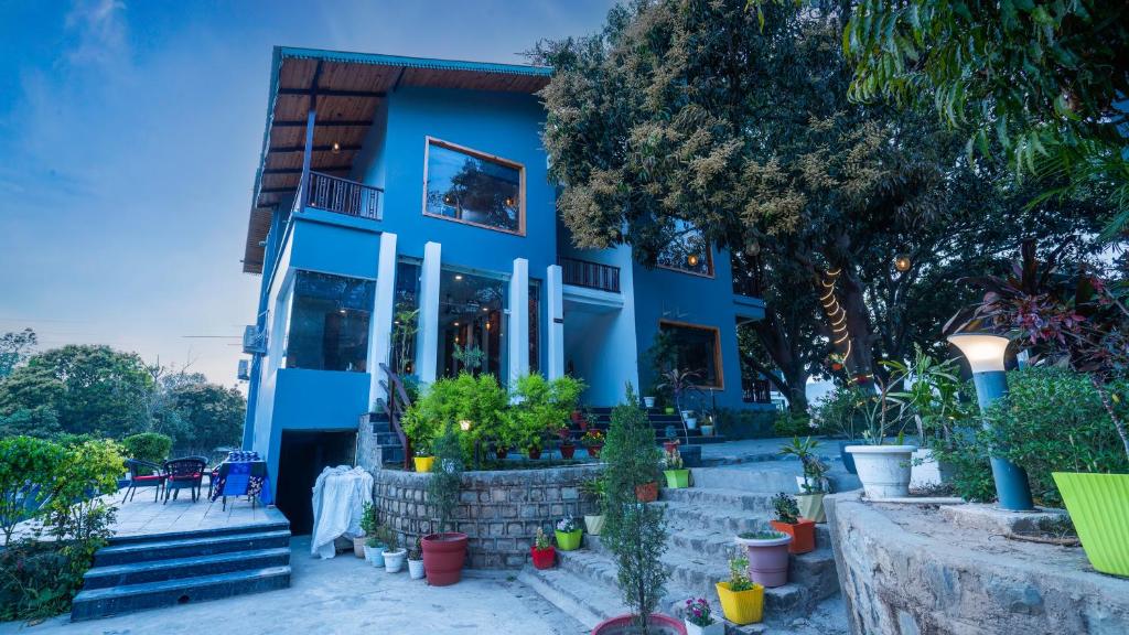 una casa azul con plantas delante en The Destin Ekaant By 3Tree Group en Belparāo