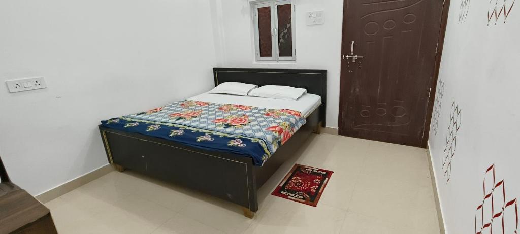 ein kleines Schlafzimmer mit einem Bett mit einer Decke darauf in der Unterkunft Maa kaushalya Guest House in Ayodhya in Ayodhya