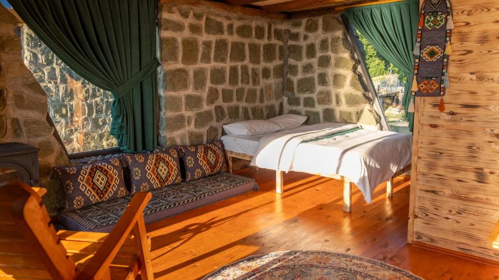 a living room with a couch and a bed in a house at Şahmaran Bungalov in Ardeşen