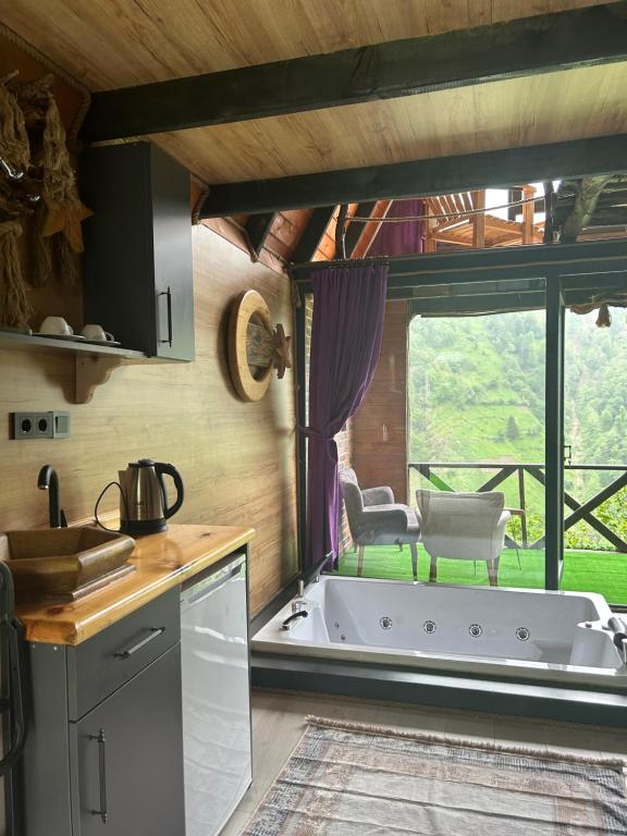 a kitchen with a tub in the middle of a room at FİÇİTA BUNGALOv in Dikkaya