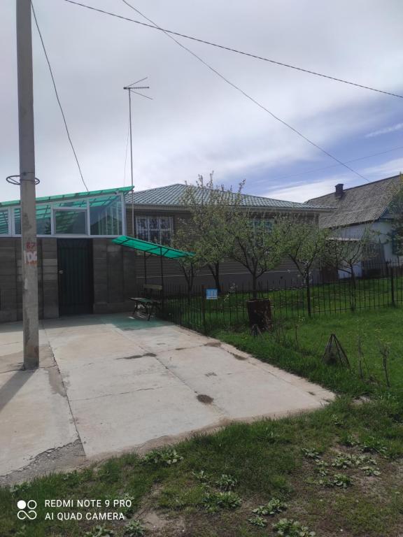 un bâtiment avec une aire de jeux dans une cour dans l'établissement Your House, à Karakol