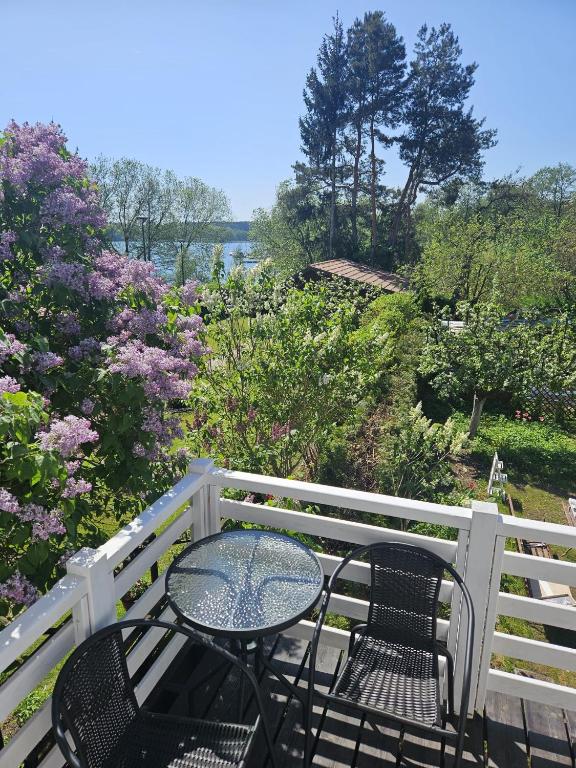 a table and chairs sitting on a balcony with flowers at Apartament nad jeziorem Ukiel in Olsztyn