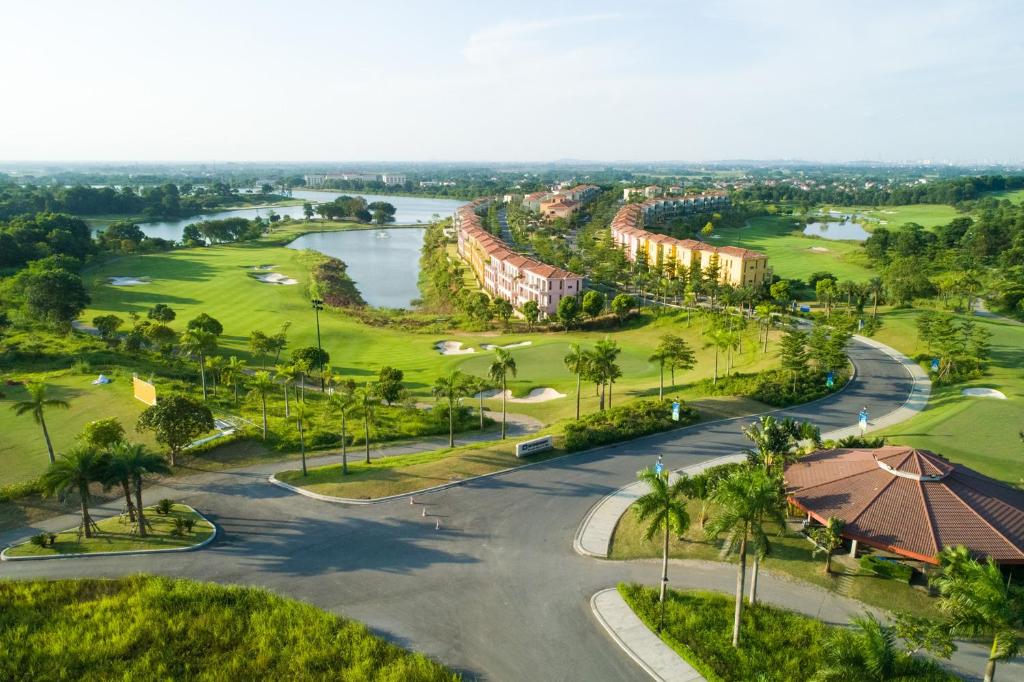 an aerial view of a resort with a river and palm trees at Wyndham Sky Lake Resort and Villas in Hanoi