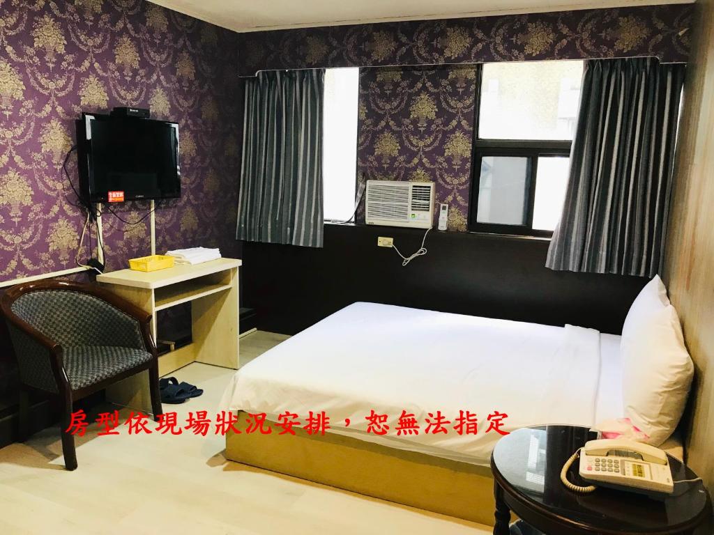 羅東鎮的住宿－貴族大旅社 ，一间卧室配有一张床、一张书桌和一台电视