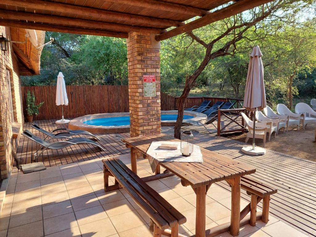 a patio with a table and chairs and a pool at Khumbula iAfrica 2 in Marloth Park