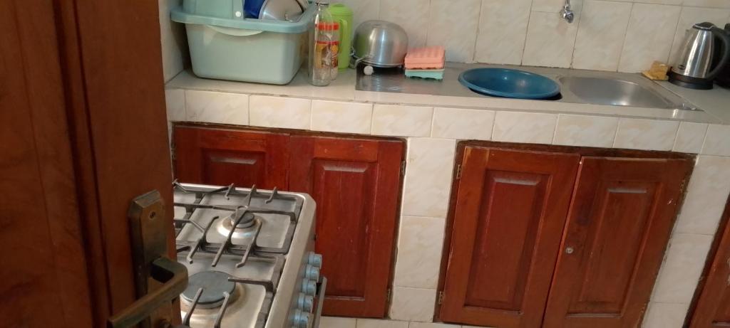 uma cozinha com um fogão e um lavatório em BG archange em Cotonou
