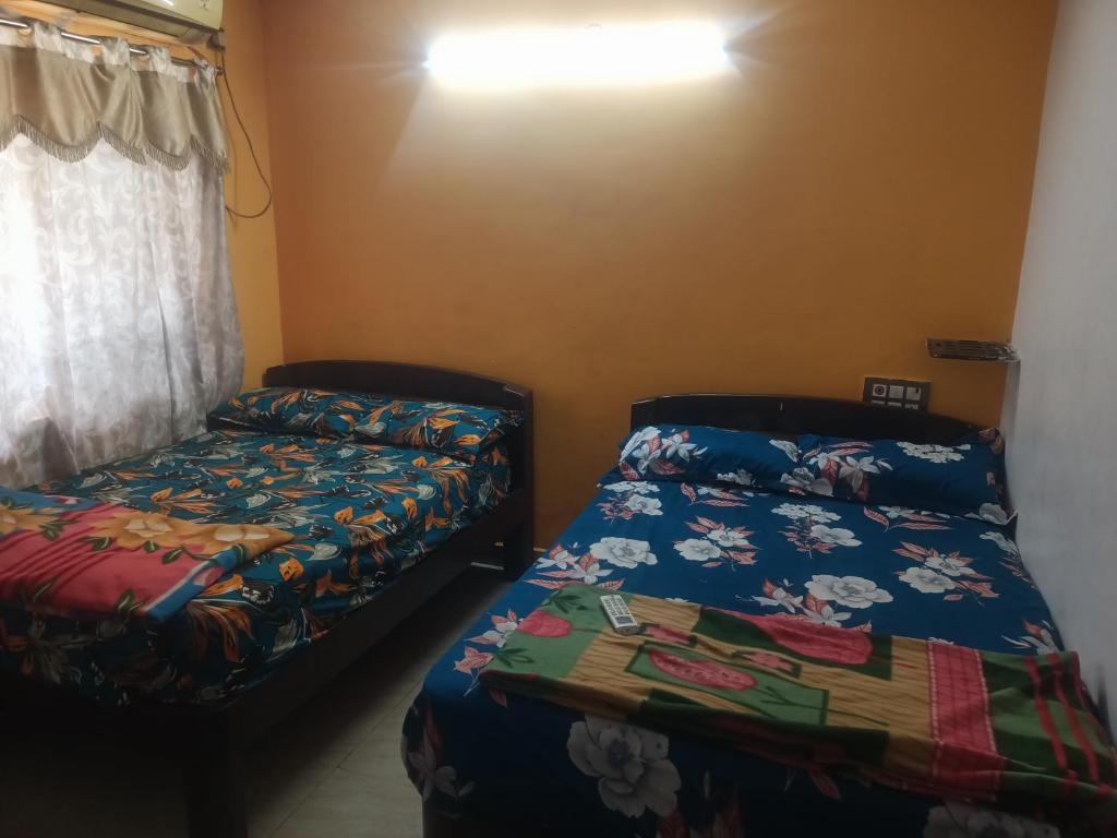 a bedroom with two beds and a window at Sapthagiri lodge in Visakhapatnam