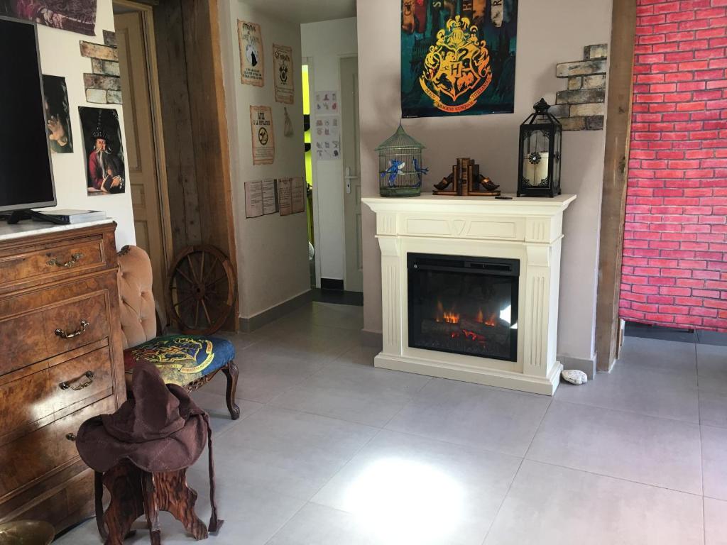 - un salon avec une cheminée et une chaise dans l'établissement L'Auberge du Sorcier, à Aniane