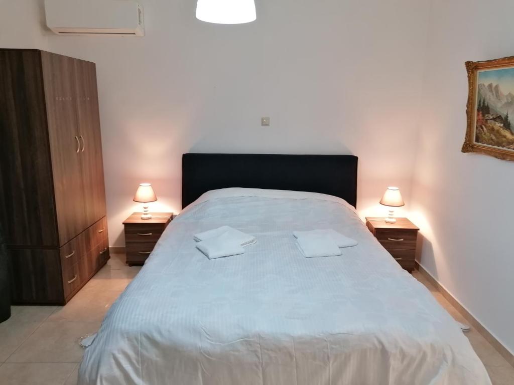 ein Schlafzimmer mit einem großen Bett mit zwei Nachttischen in der Unterkunft B.K.group3 in Artemida
